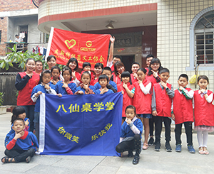 GESTER mostrando un corazón amoroso para los estudiantes de la escuela Ba Xian Zhuo